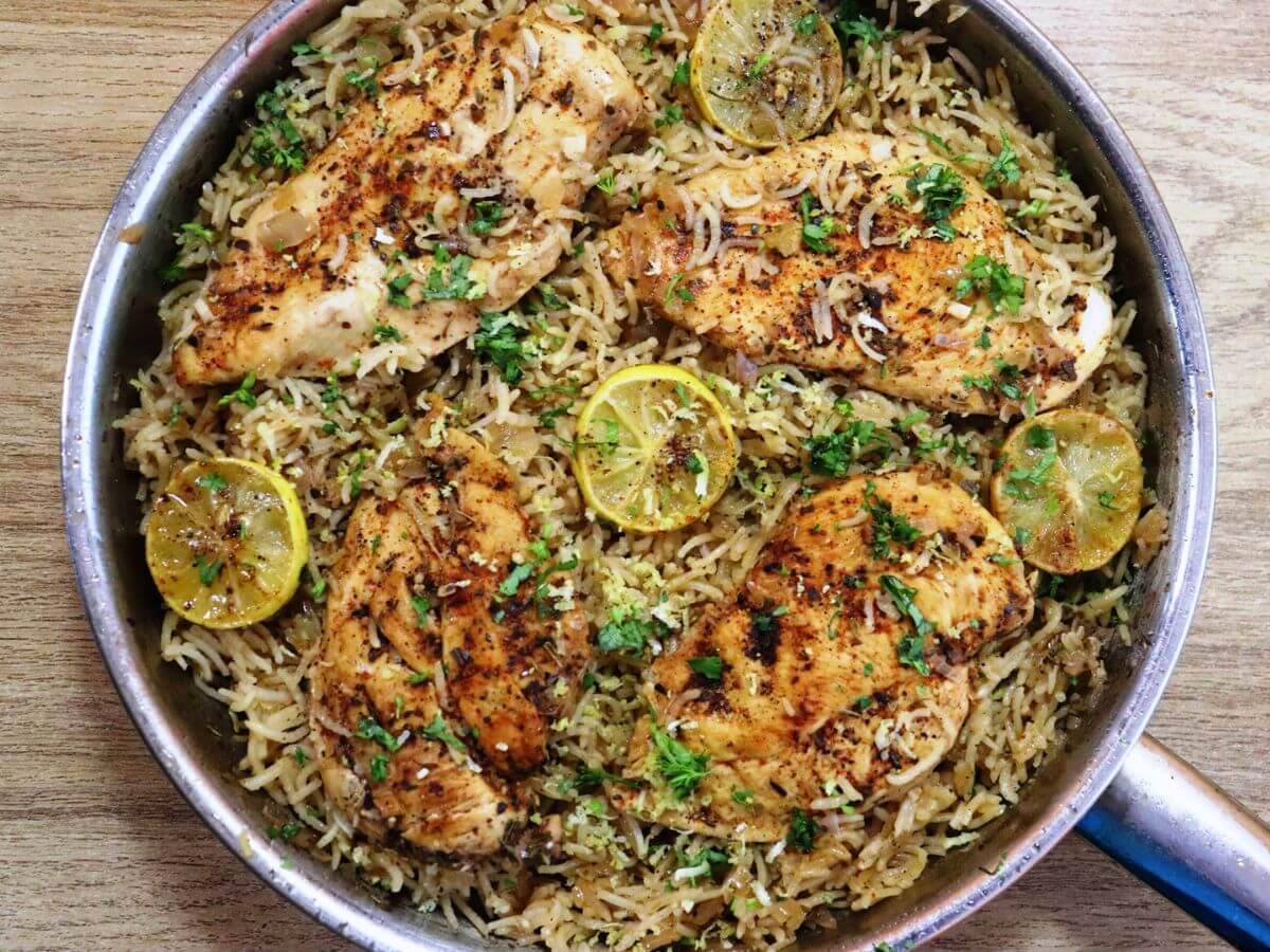 close-up of greek lemon chicken rice in a skillet.