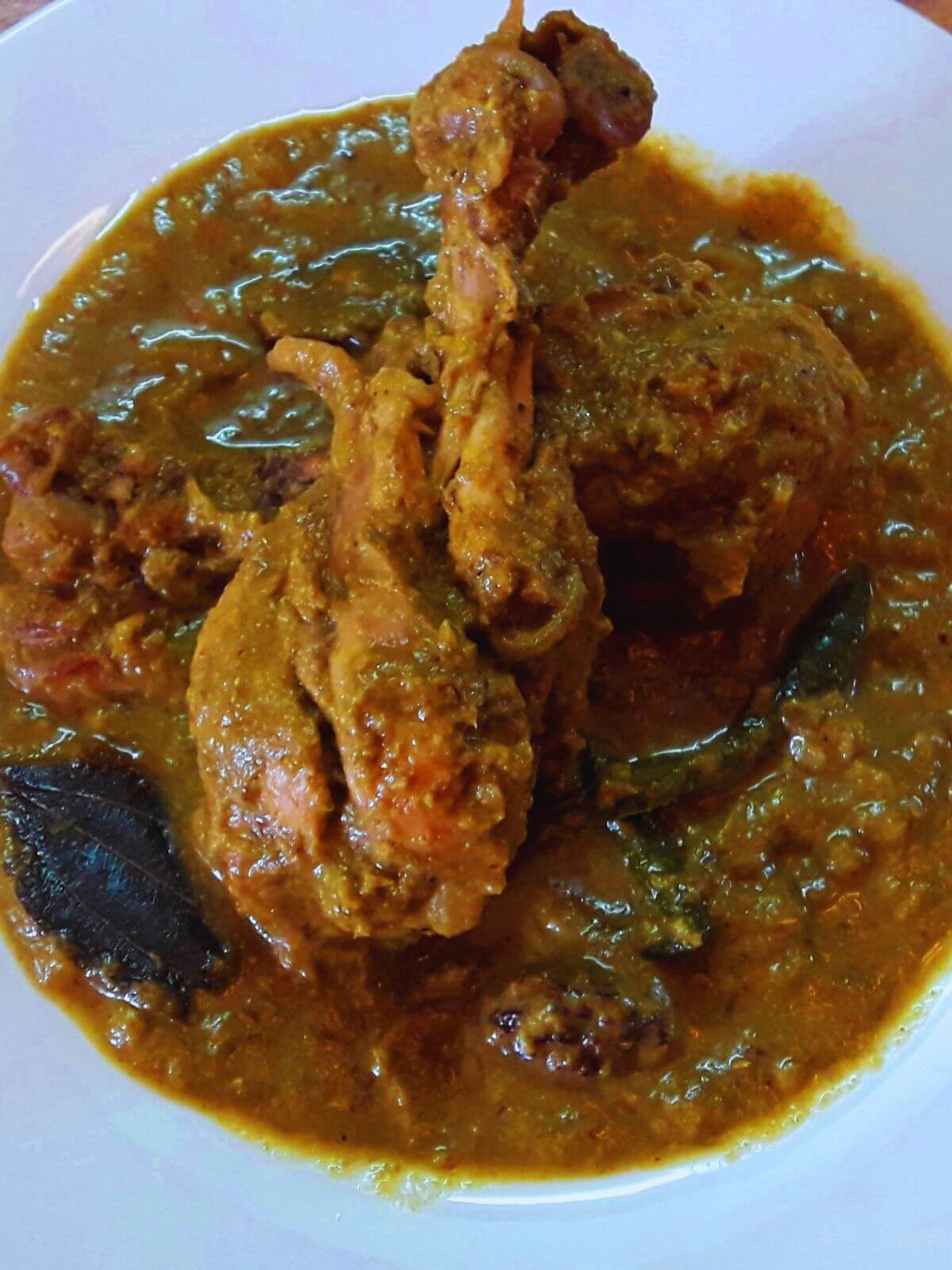 close-up of hyderabadi green chicken curry served in a plate.