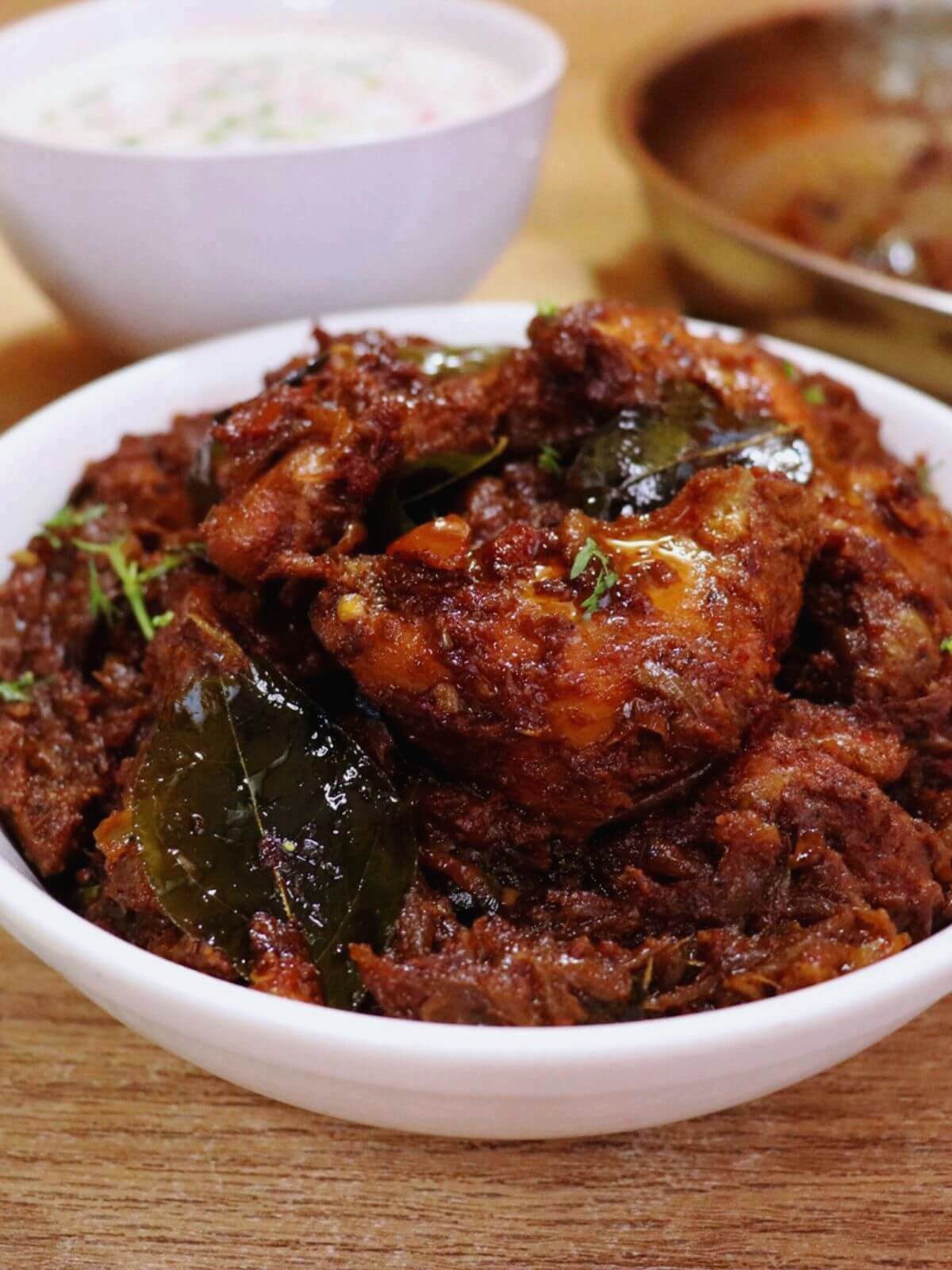 close-up of kerala chicken roast served in a white bowl.
