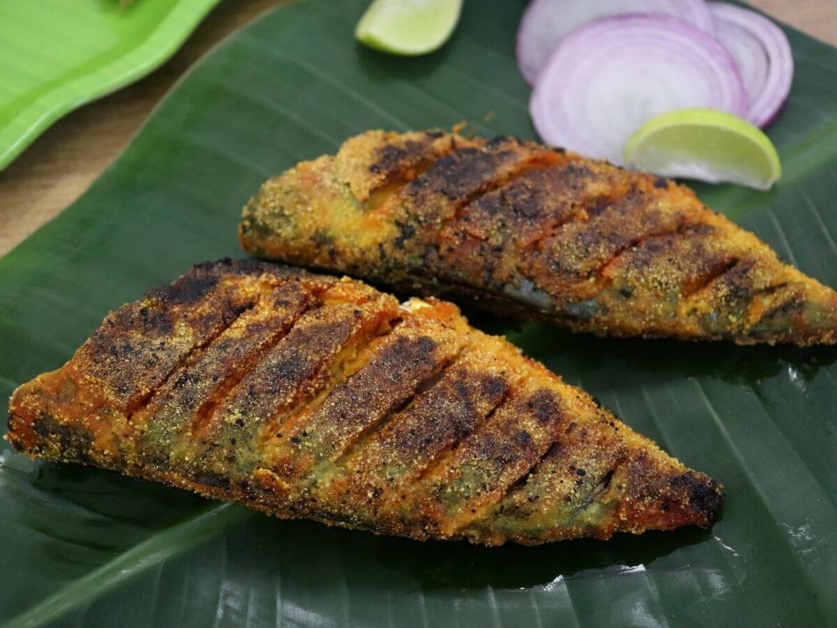 A close-up of two mackerel fry on a banana leaf.