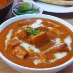 close-up of paneer butter masala in a bowl.