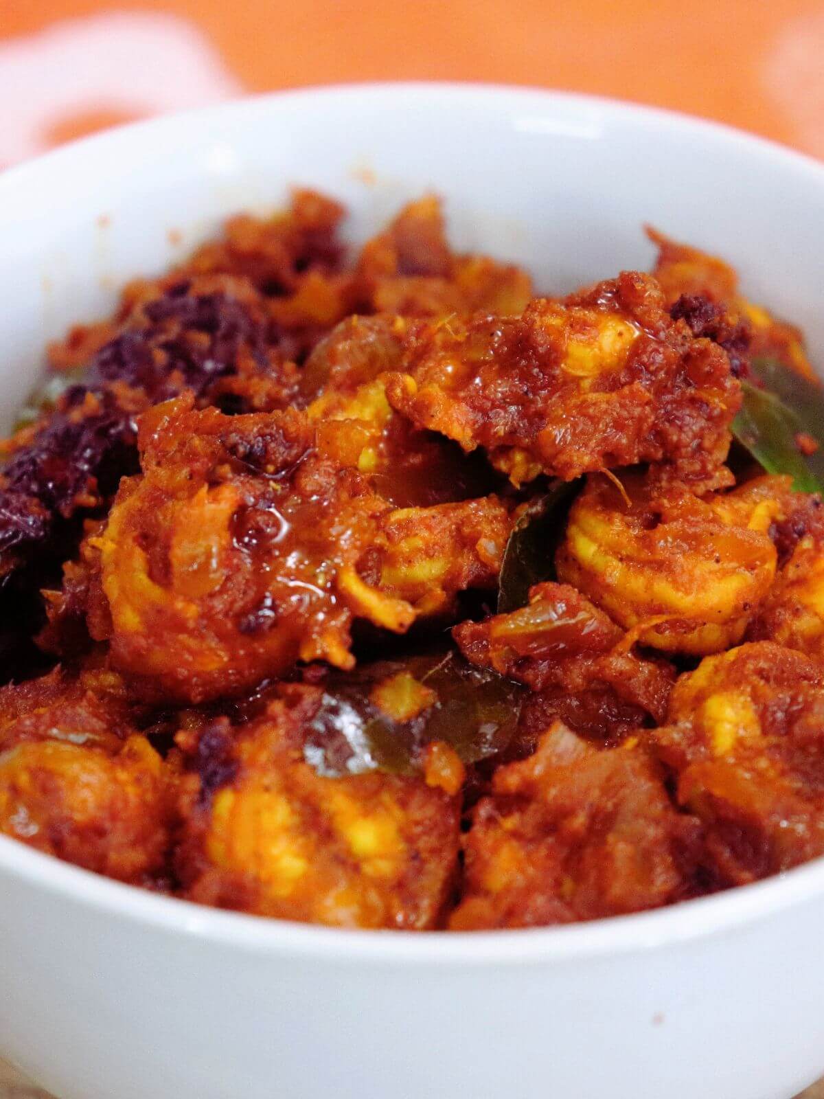 close-up of prawn masala served in a white bowl.