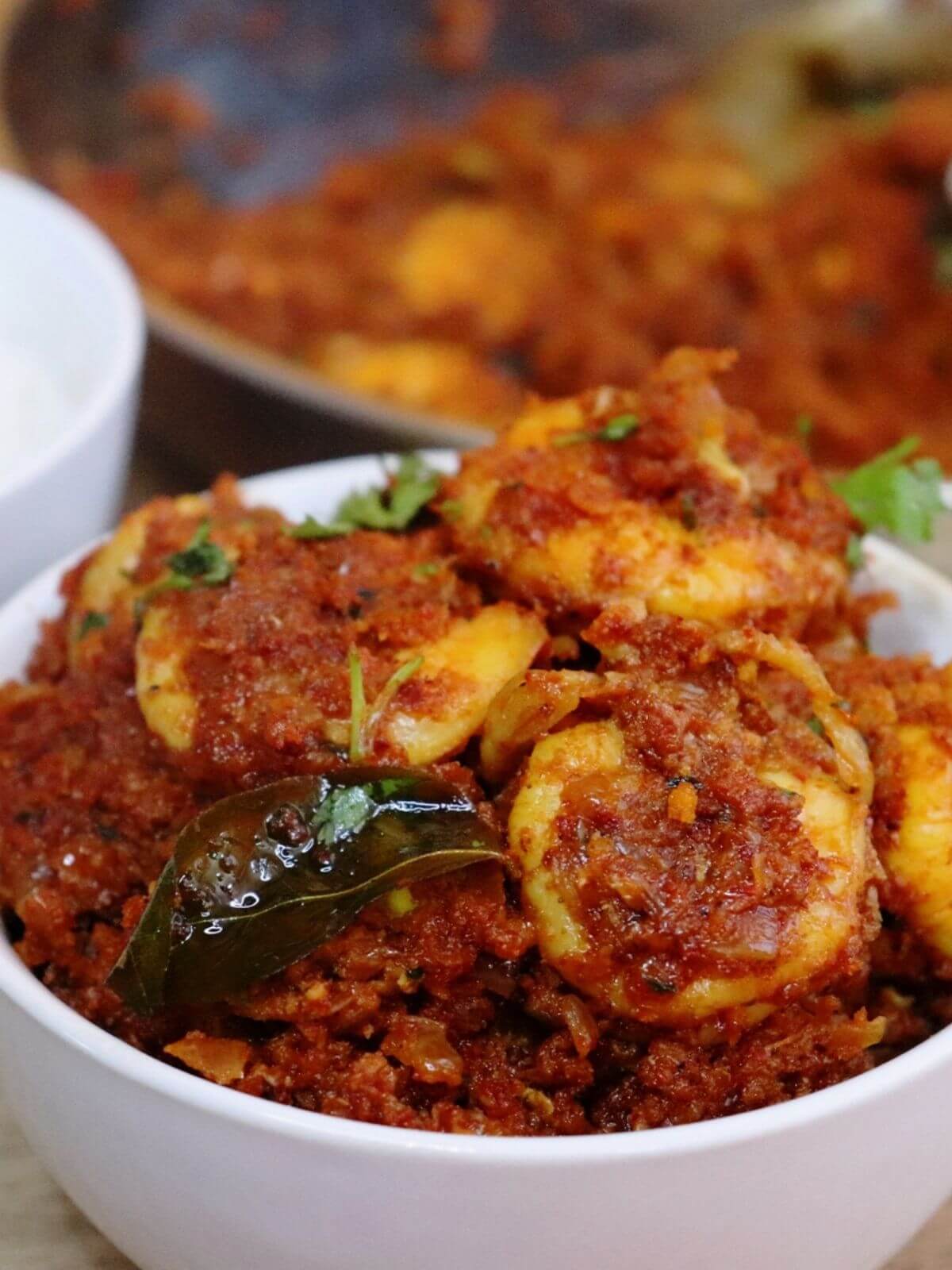 close-up of prawn sukka served in a white bowl.
