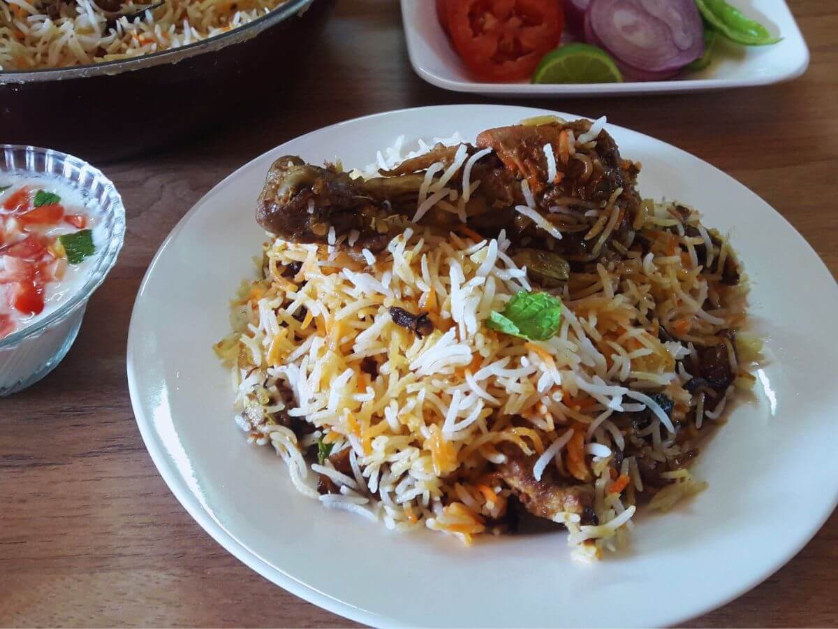 close-up of awadhi chicken biryani served on a plate.