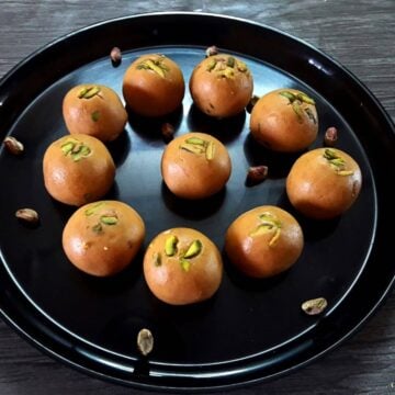 close-up of besan ladoo served in a black plate.