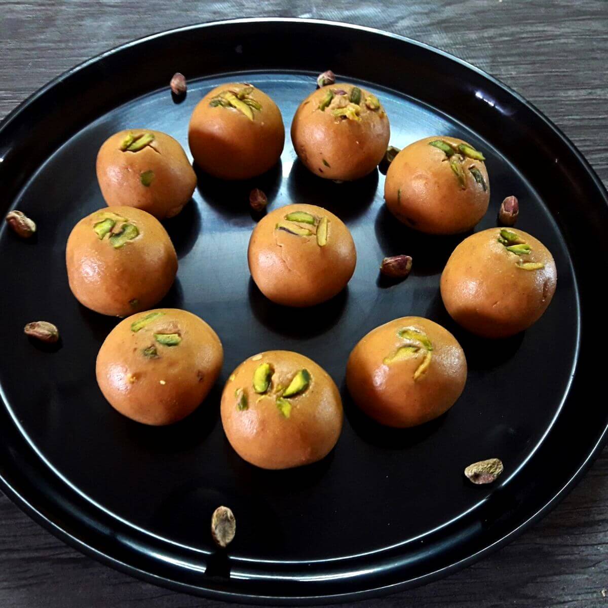 close-up of besan ladoo served in a black plate.