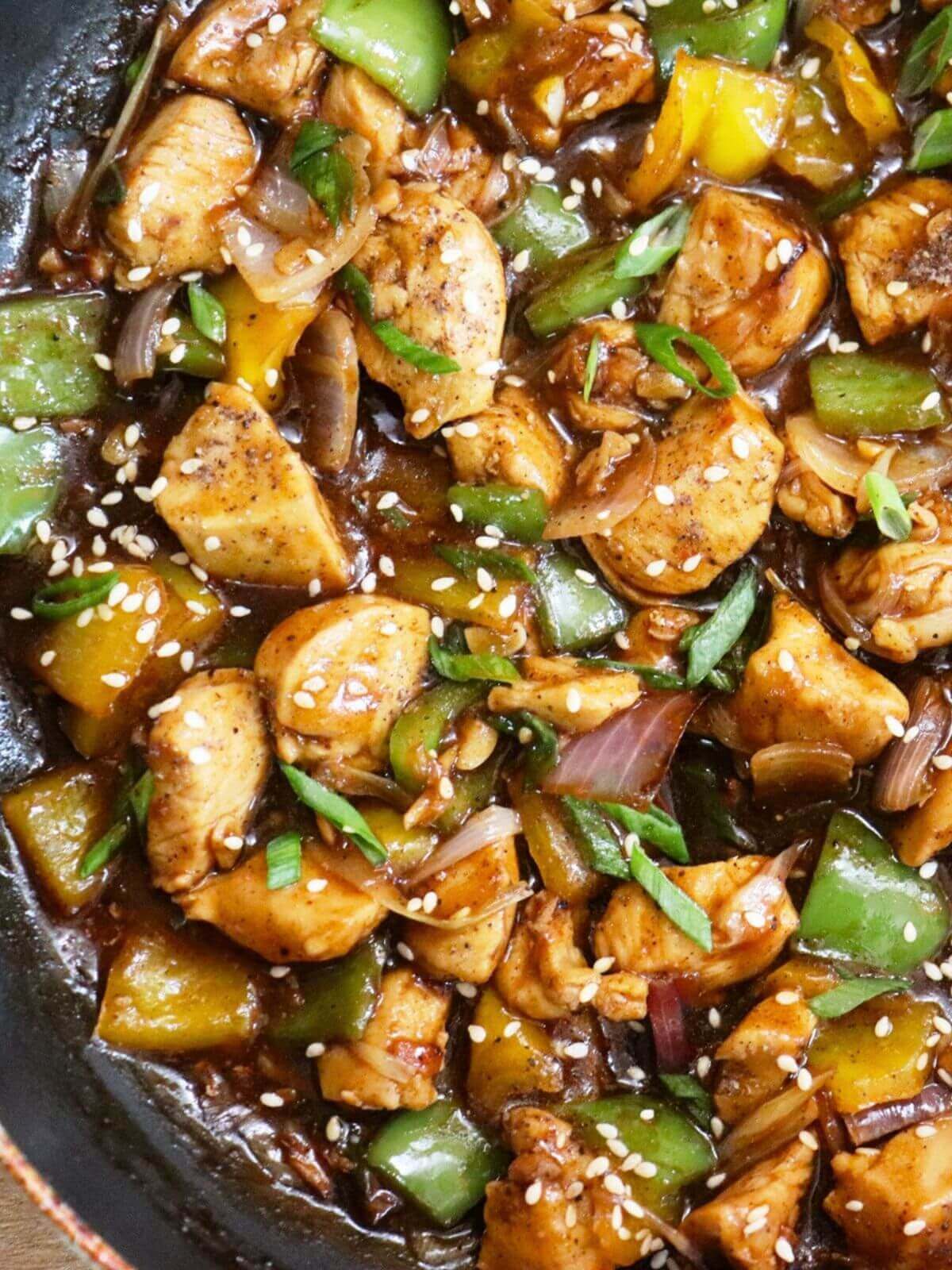close-up of black pepper chicken stir fry in a pan.