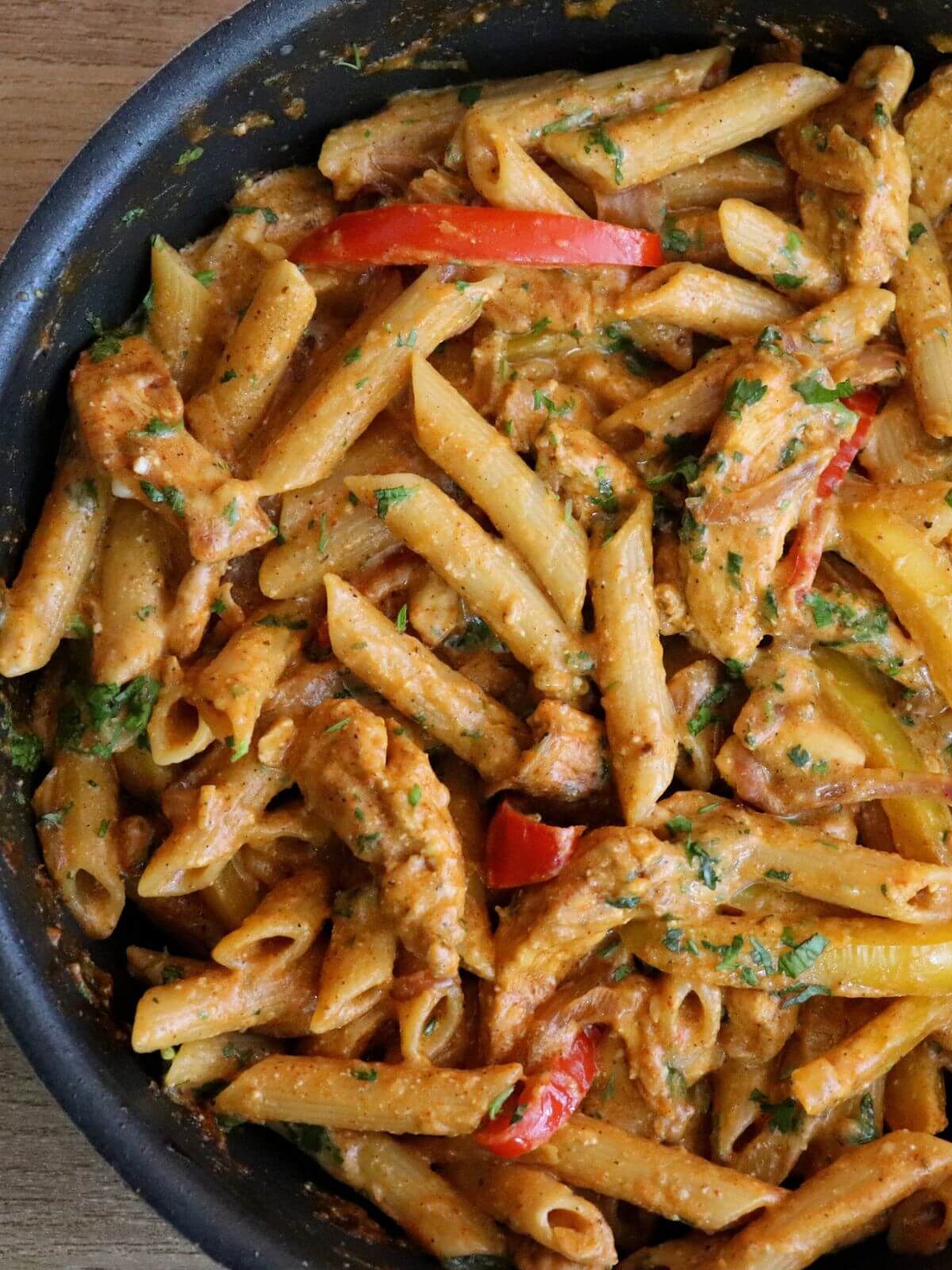 close-up of cajun chicken pasta in a pan.