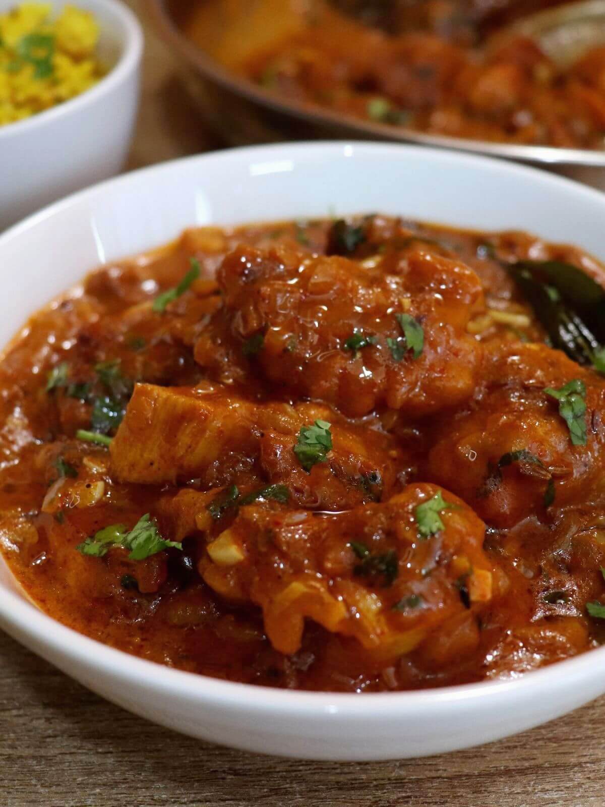 close-up of chicken 65 gravy served in a white bowl.