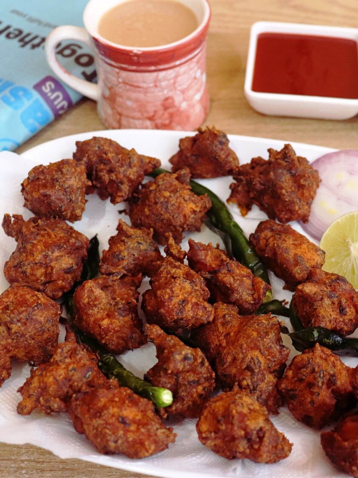 close-up of crispy chicken pakoras. Served with tea and ketchup.