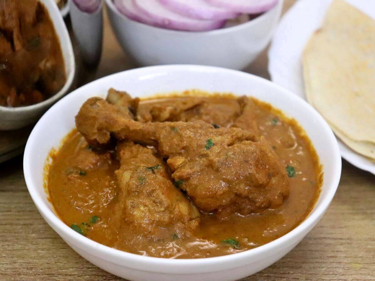 close-up of chicken salna served in a white bowl.