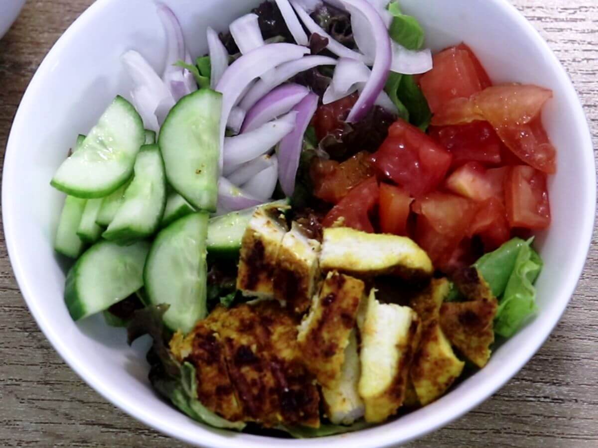assembling chicken shawarma salad bowl.