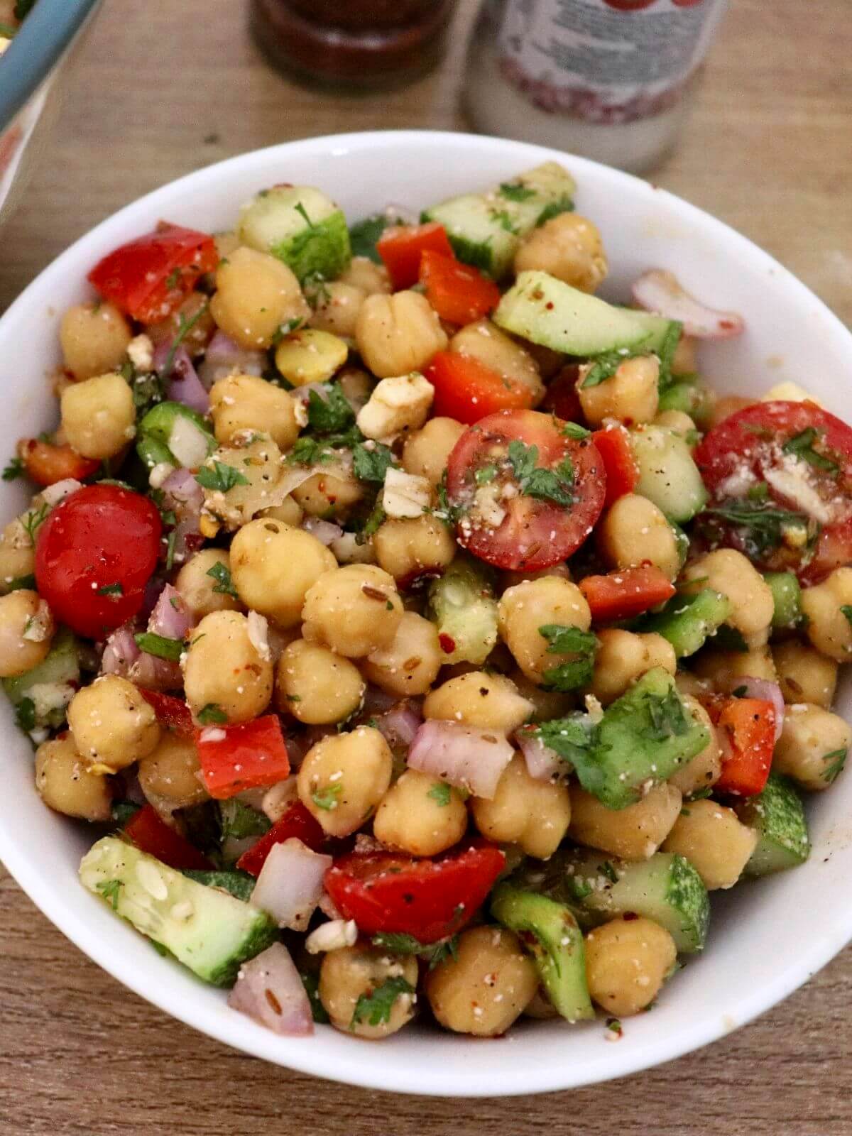 close-up of chickpea salad served in a white bowl.