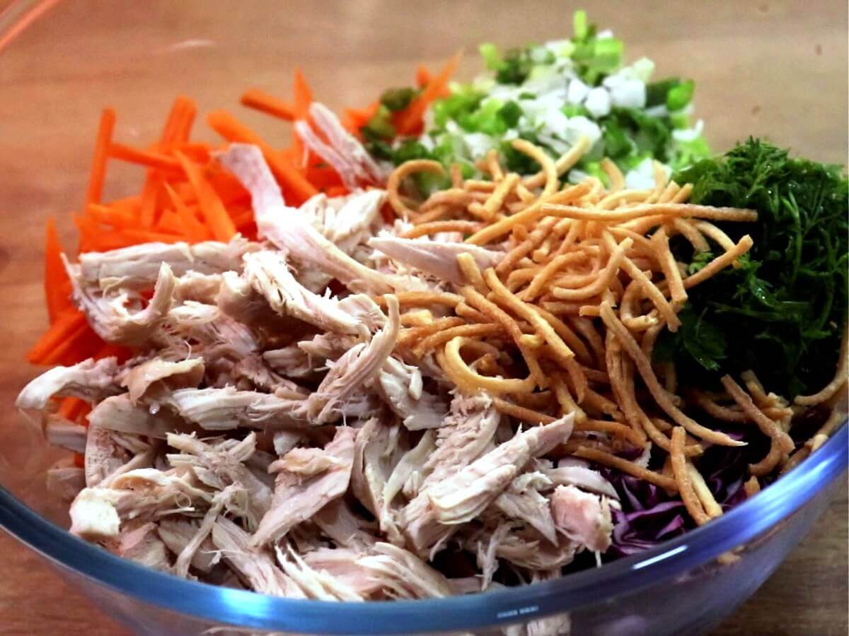 assembling the chicken salad ingredients in a mixing bowl.