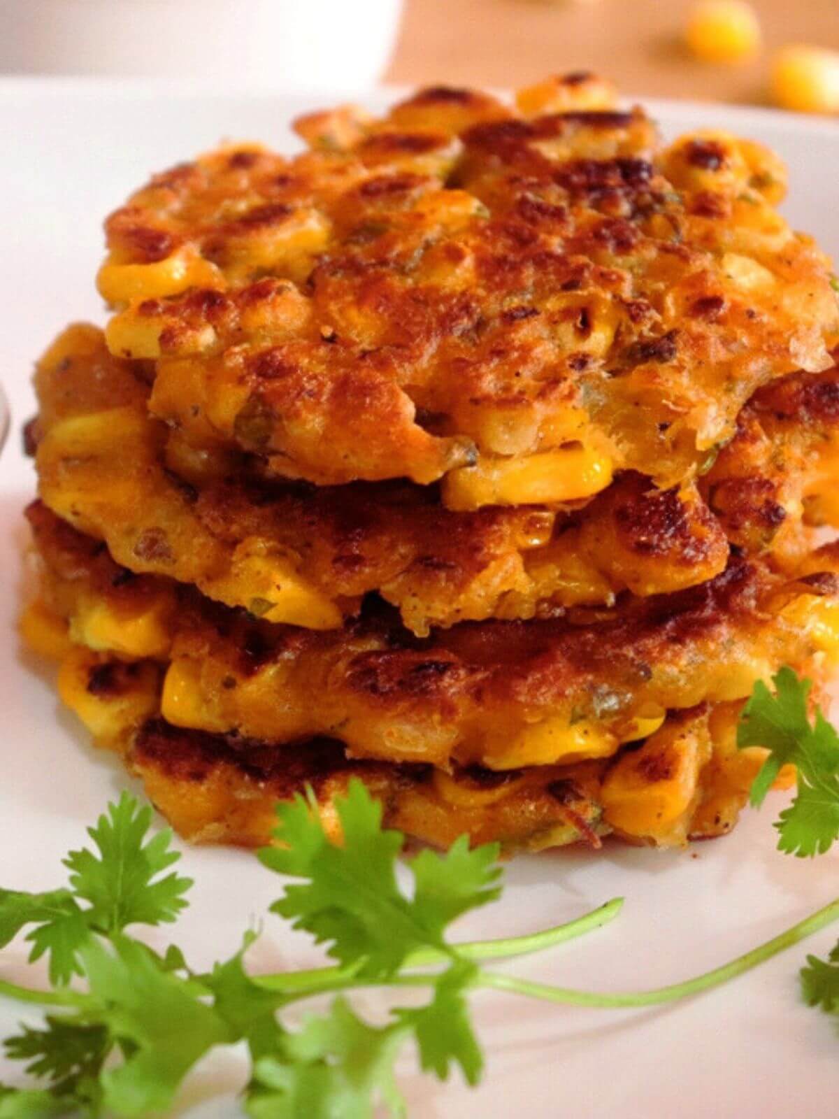close-up of corn fritters stacked on a plate.