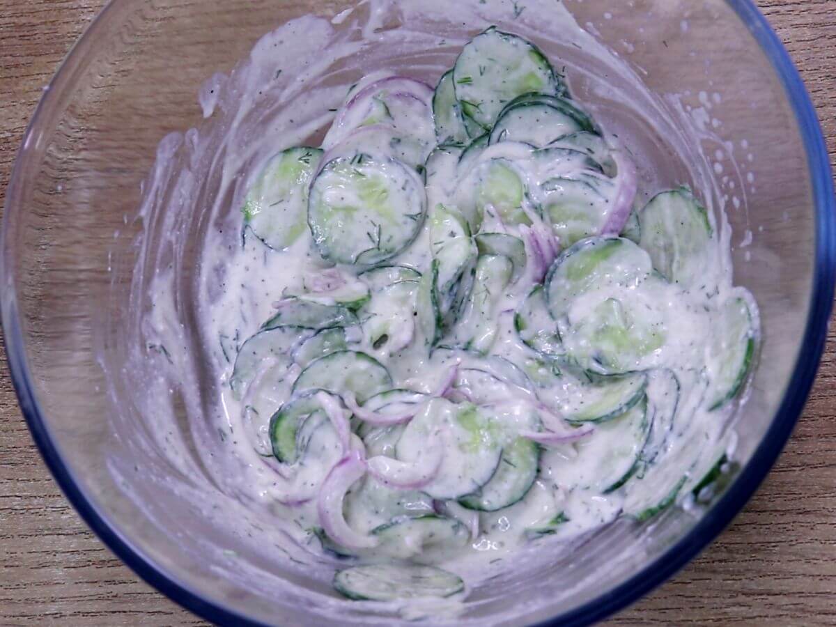 creamy cucumber salad with Greek yogurt in a white bowl.