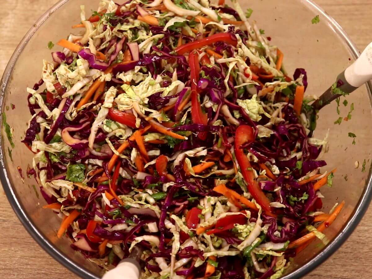 Mixing the slaw with the dressing.