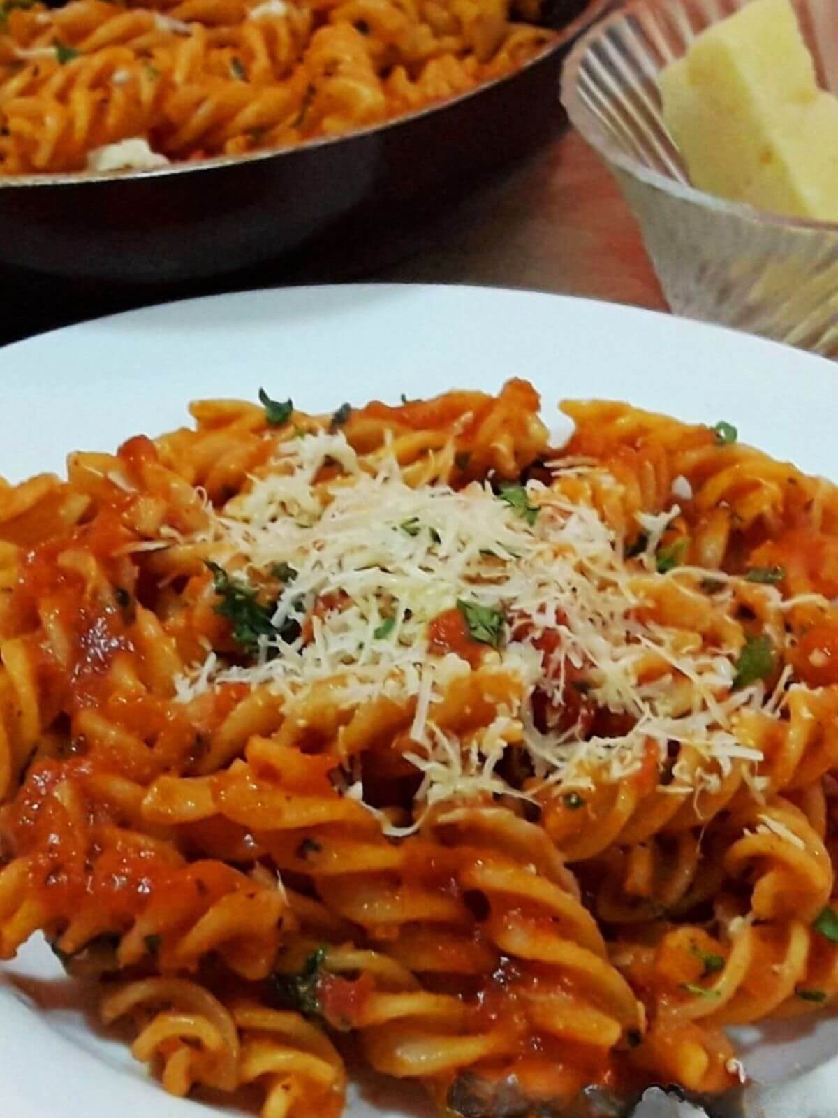 close-up of tomato pasta served in a plate.