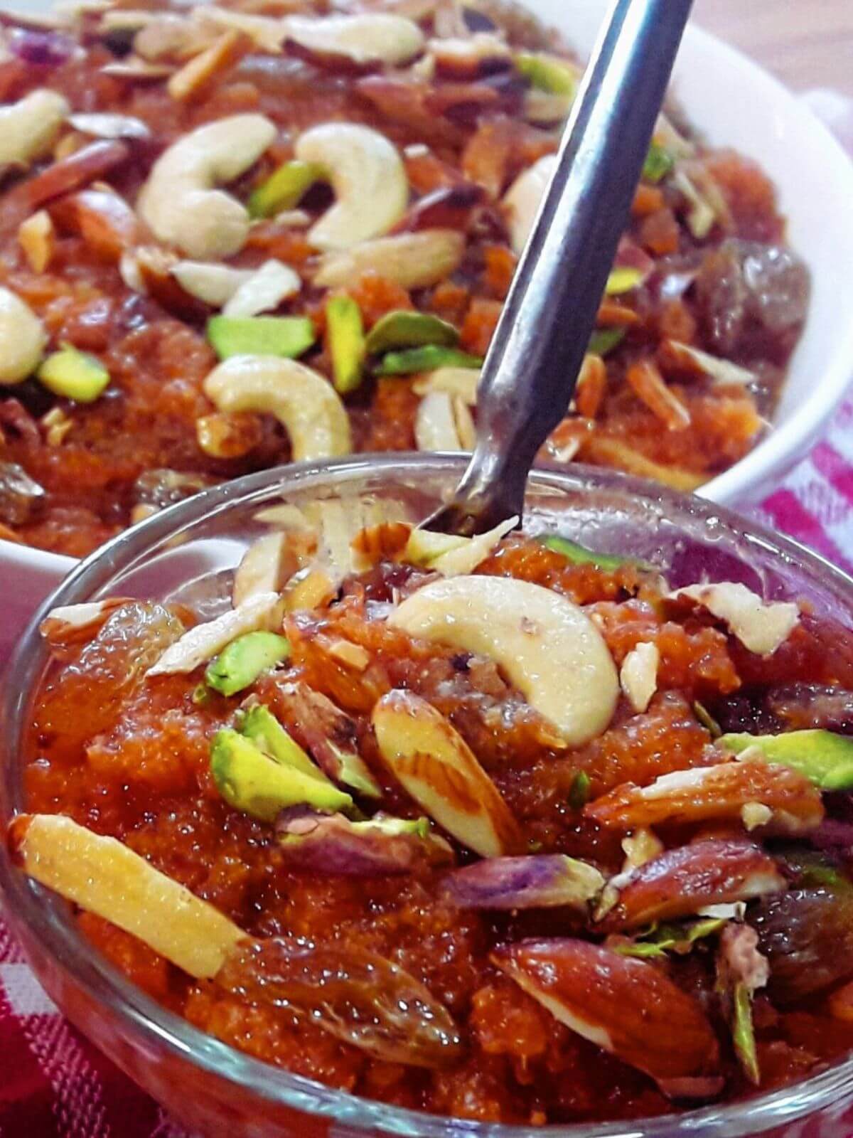 close-up of gajar ka halwa served in a glass bowl.