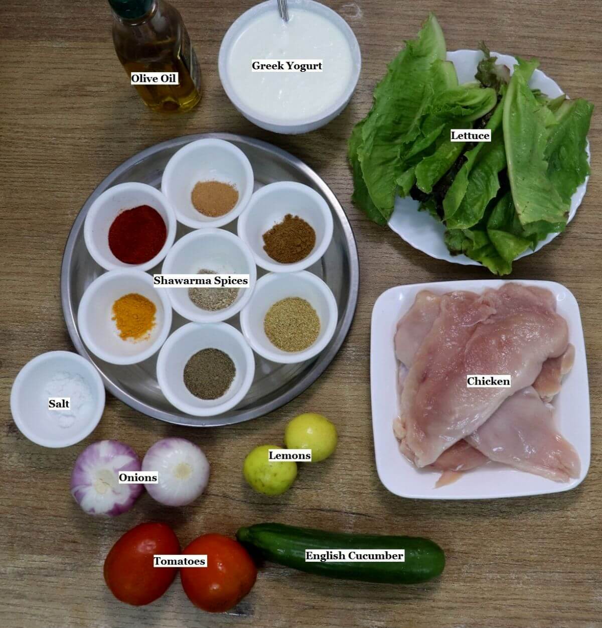 individually labelled ingredients to make chicken shawarma salad bowl are laid out on a table.