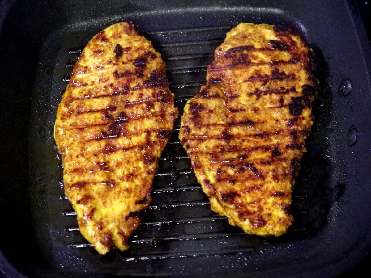 close-up of grilled chicken shawarma in a pan.
