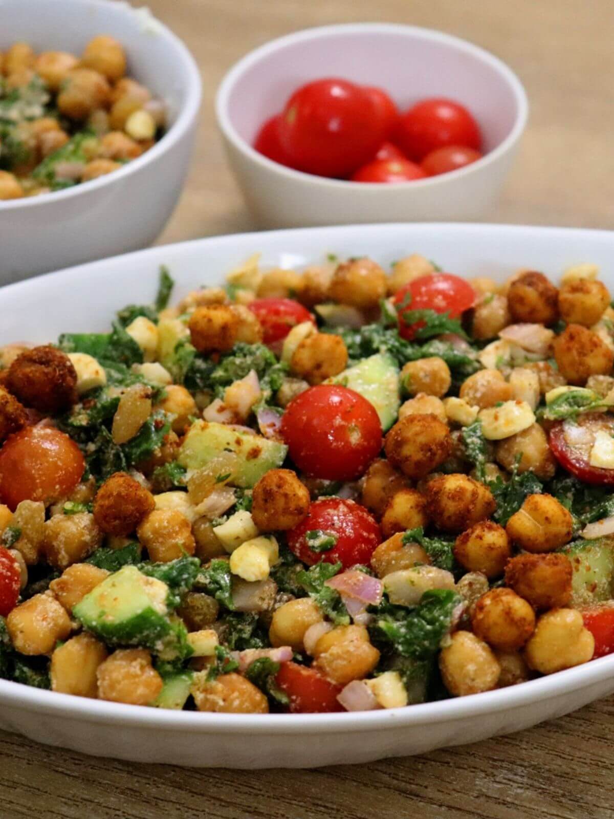 Close-up of Mediterranean kale and chickpea salad with feta, tomatoes, and lemon vinaigrette.