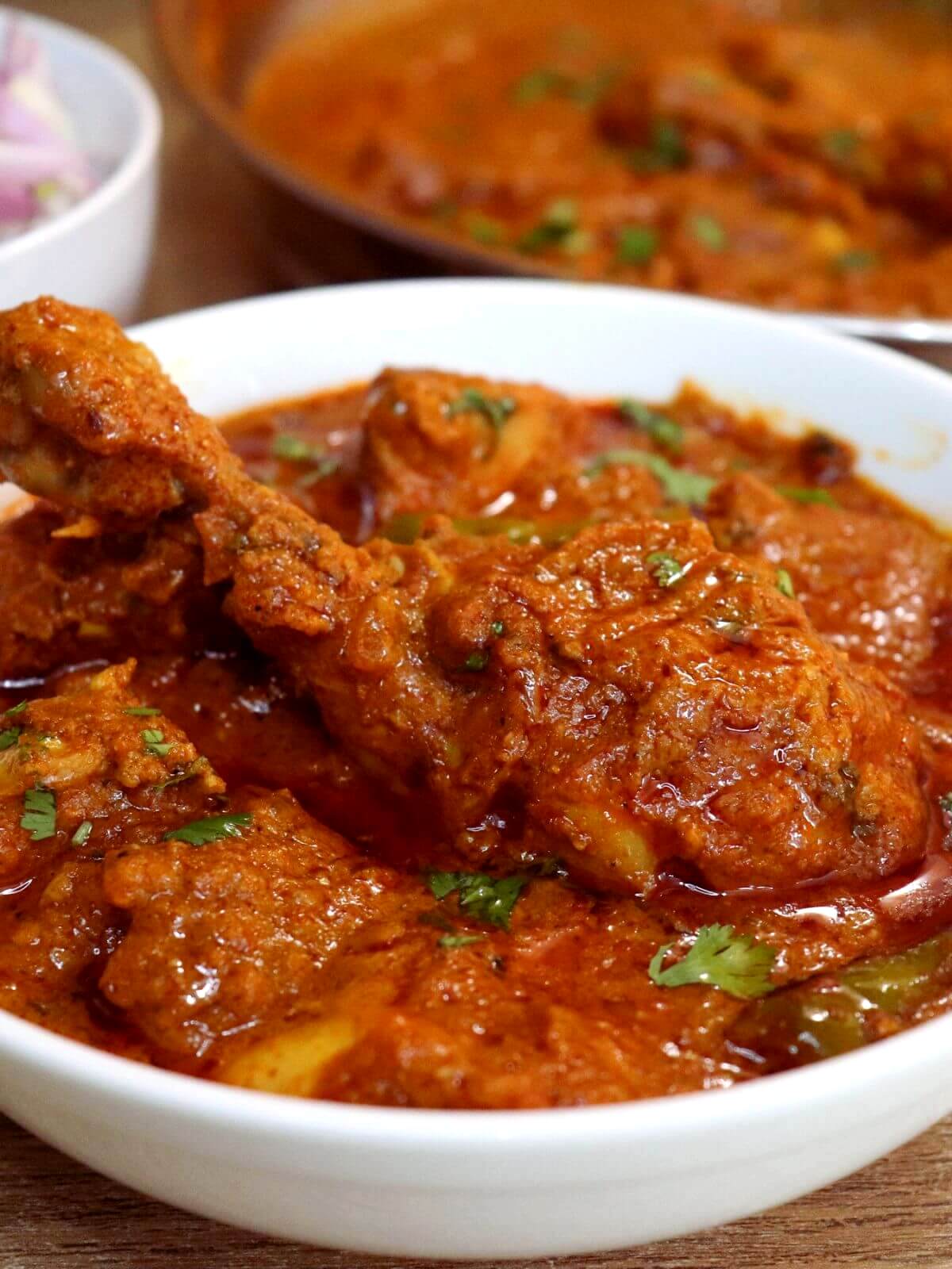 close-up of kashmiri chicken curry in a bowl.