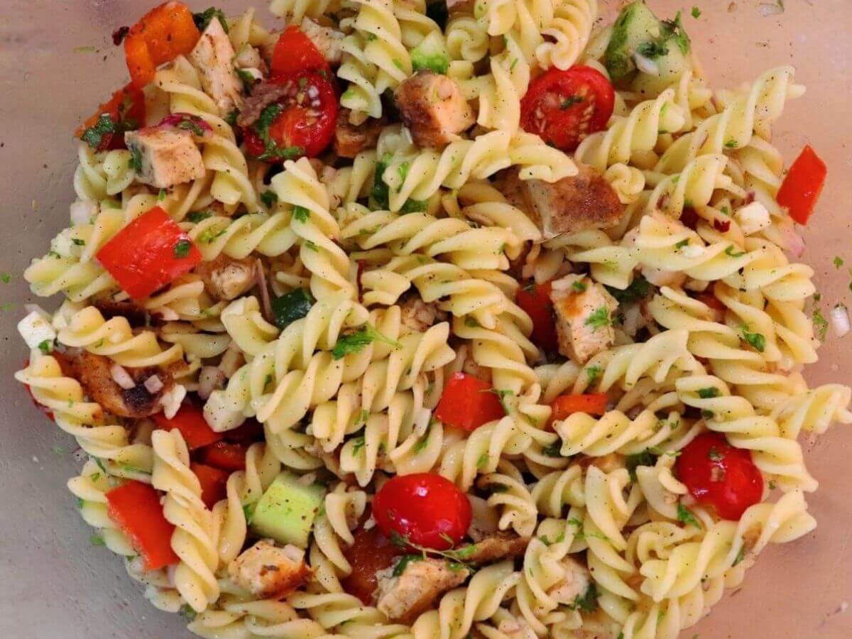 close-up of lemon chicken pasta salad in a mixing bowl.