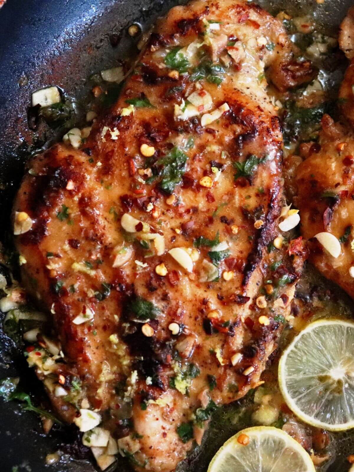 close-up of lemon garlic chicken in a pan.