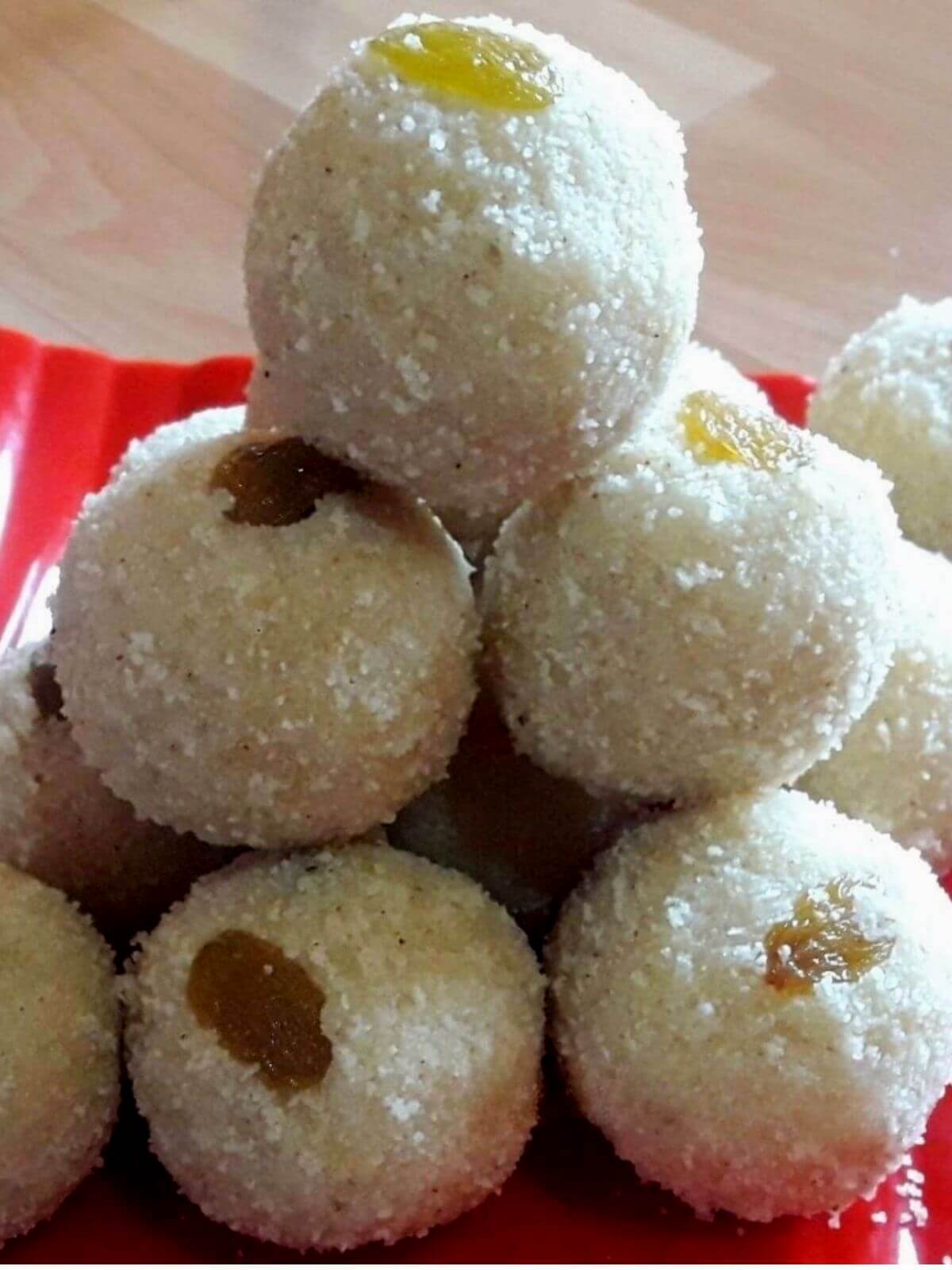 close-up of rava ladoo stacked on a red color plate.