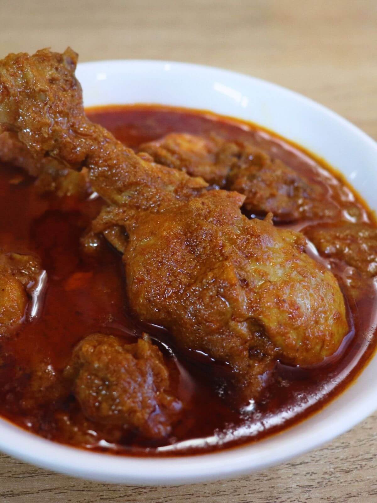close-up of malvani chicken curry served in a bowl.
