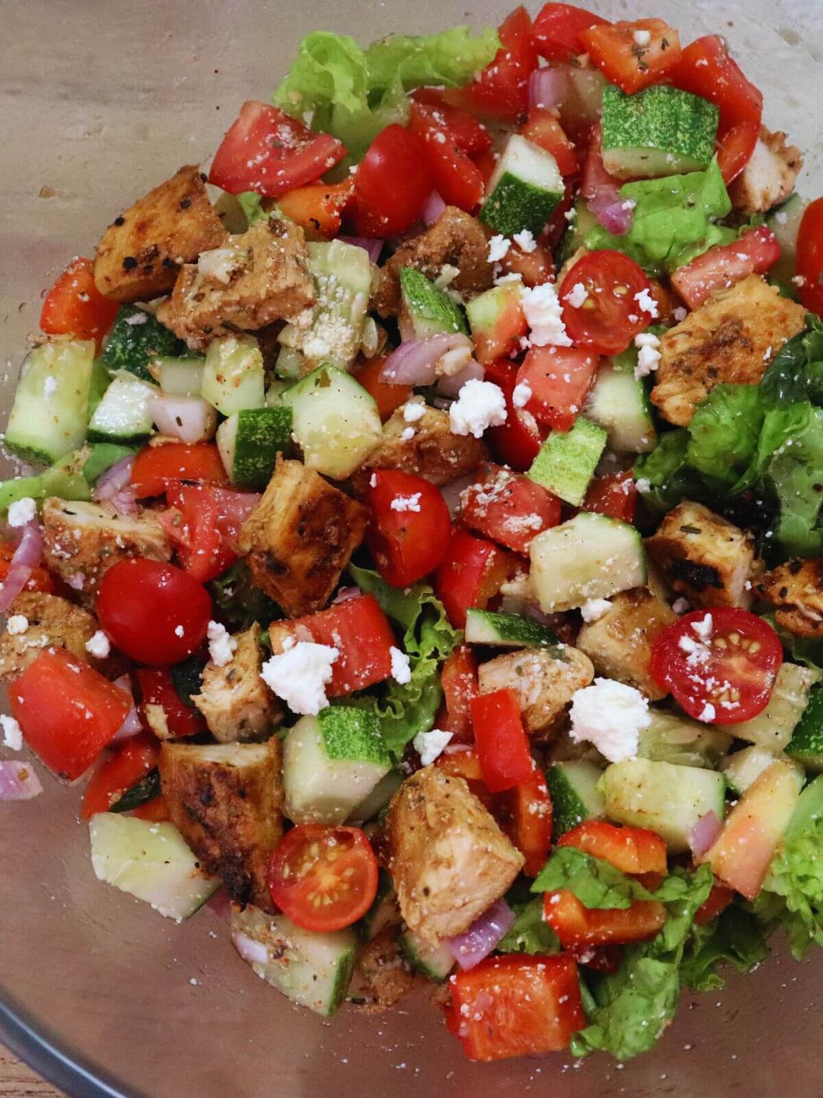 close-up of mediterranean chicken salad in a mixing bowl.