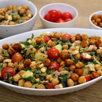 Colorful close-up of kale chickpea salad with lemon vinaigrette and feta crumbles.