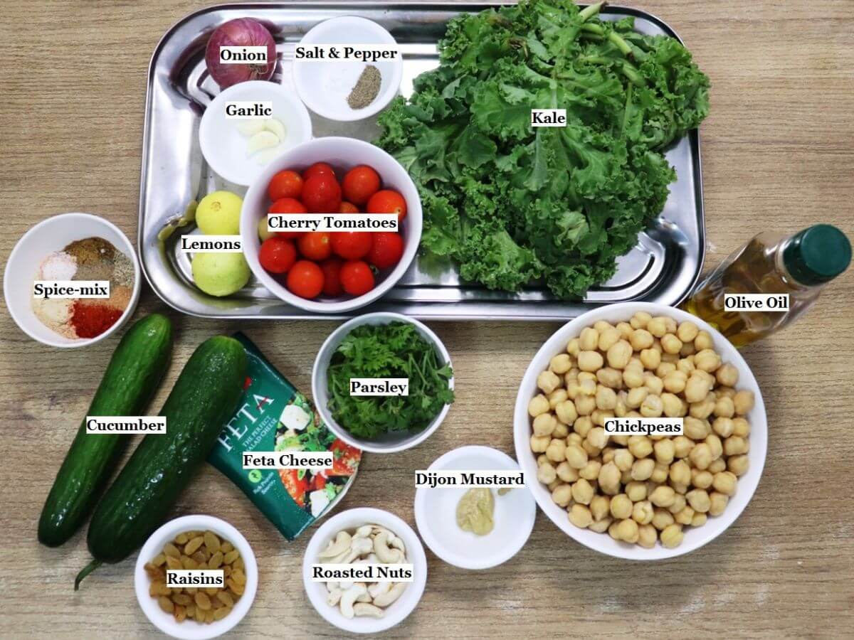 individually labeled ingredients to make kale and chickpea salad are laid out on a table.
