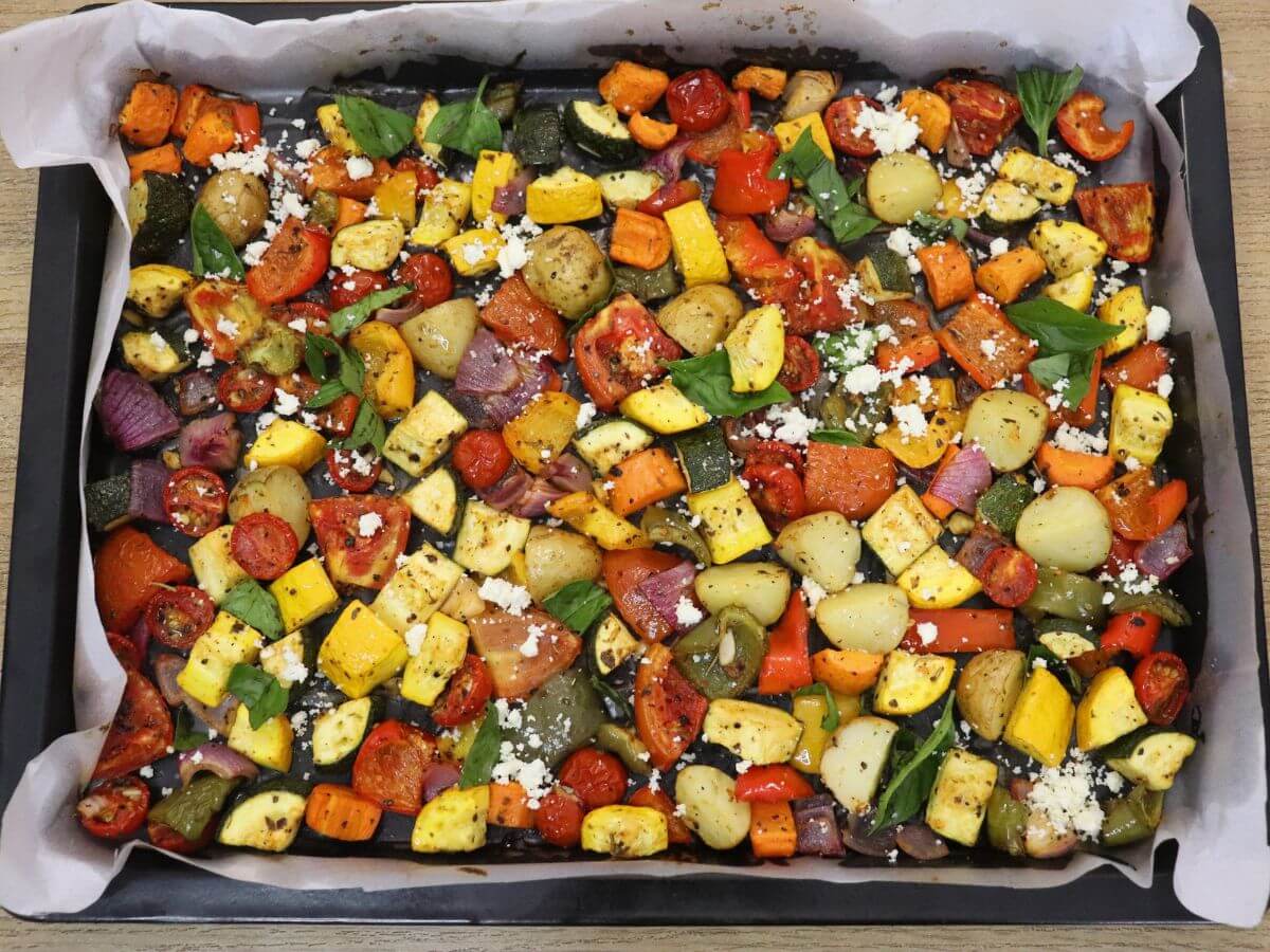 close-up of mediterranean oven roasted vegetables in a baking tray.