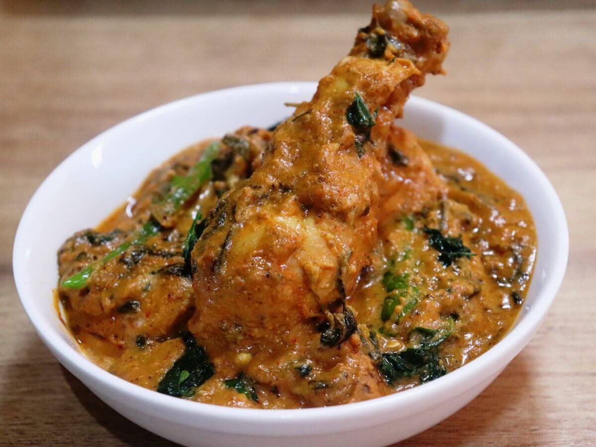 close-up of methi chicken served in a white bowl.