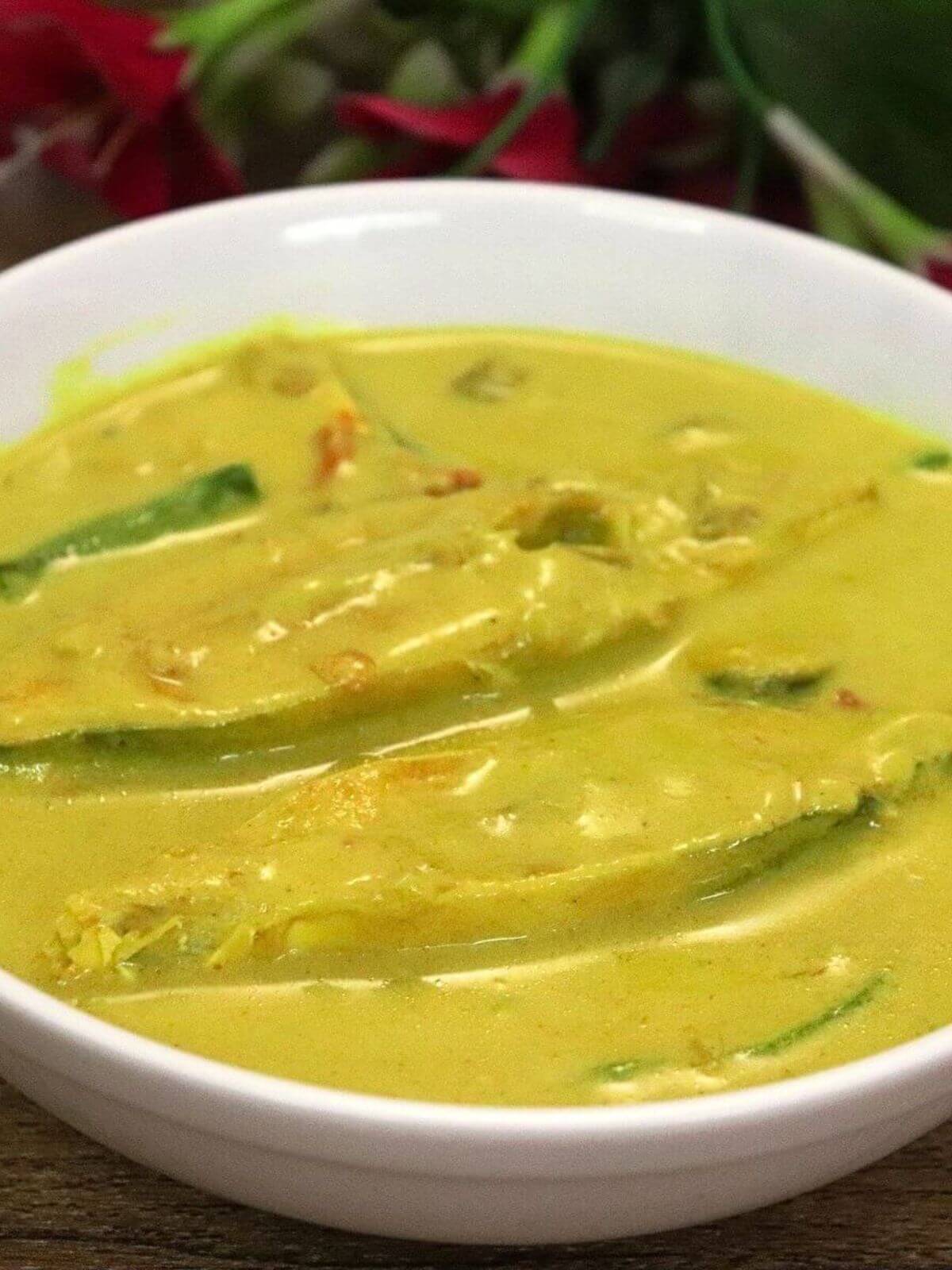 A close-up of goan caldine curry made with pomfret fish, served in a bowl.