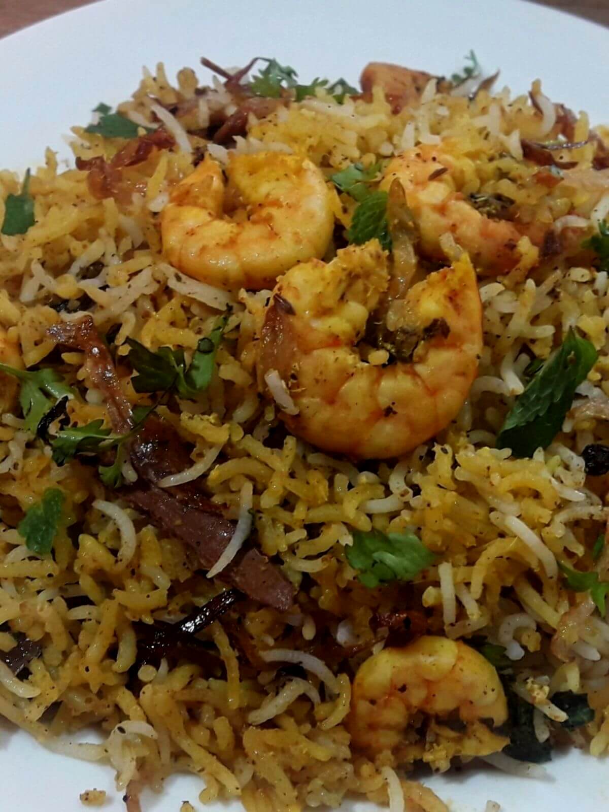 close-up of prawn biryani served on a plate.