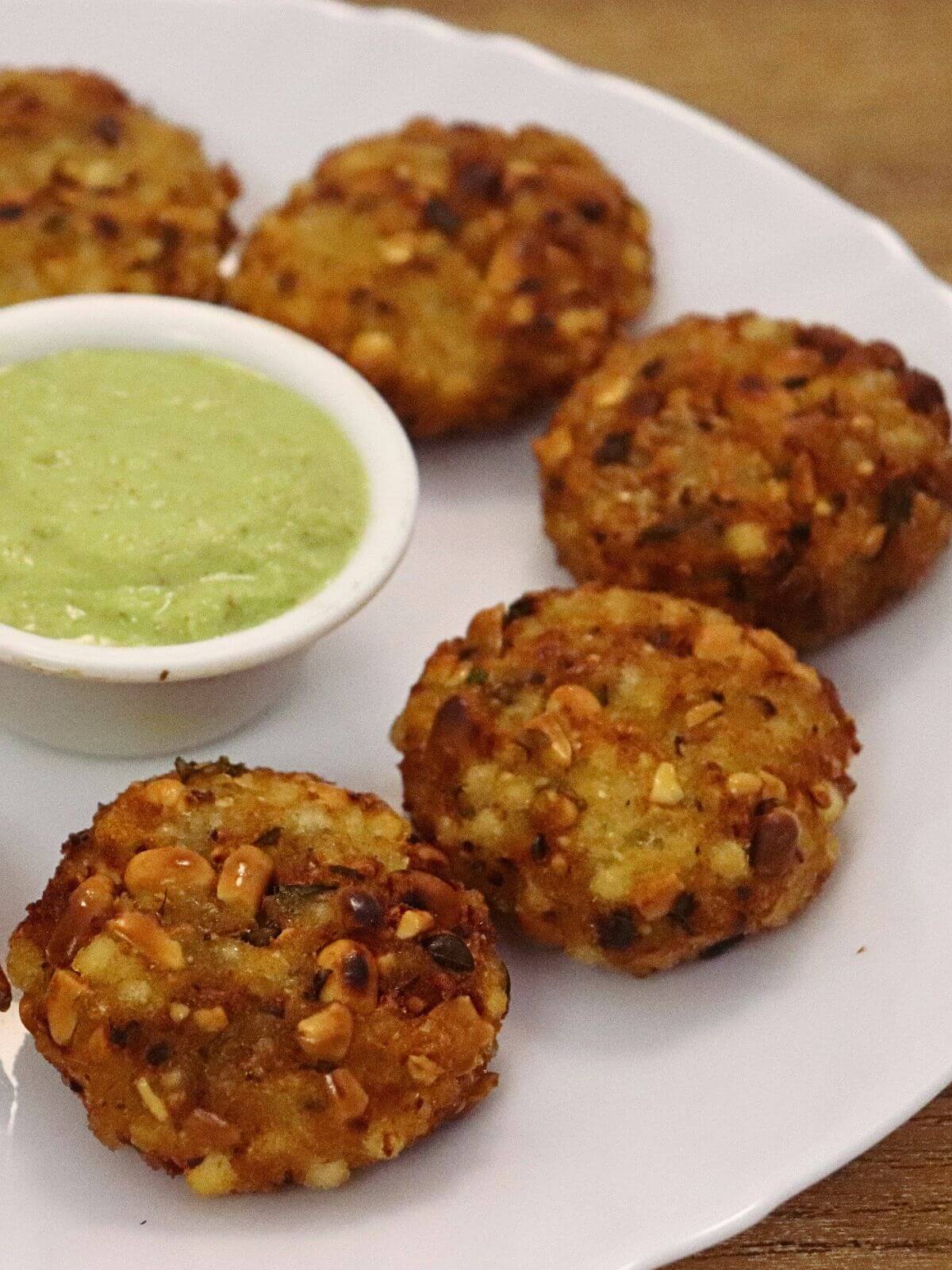 close-up of maharashtrian sabudana vada served on a plate with coconut chutney on side.