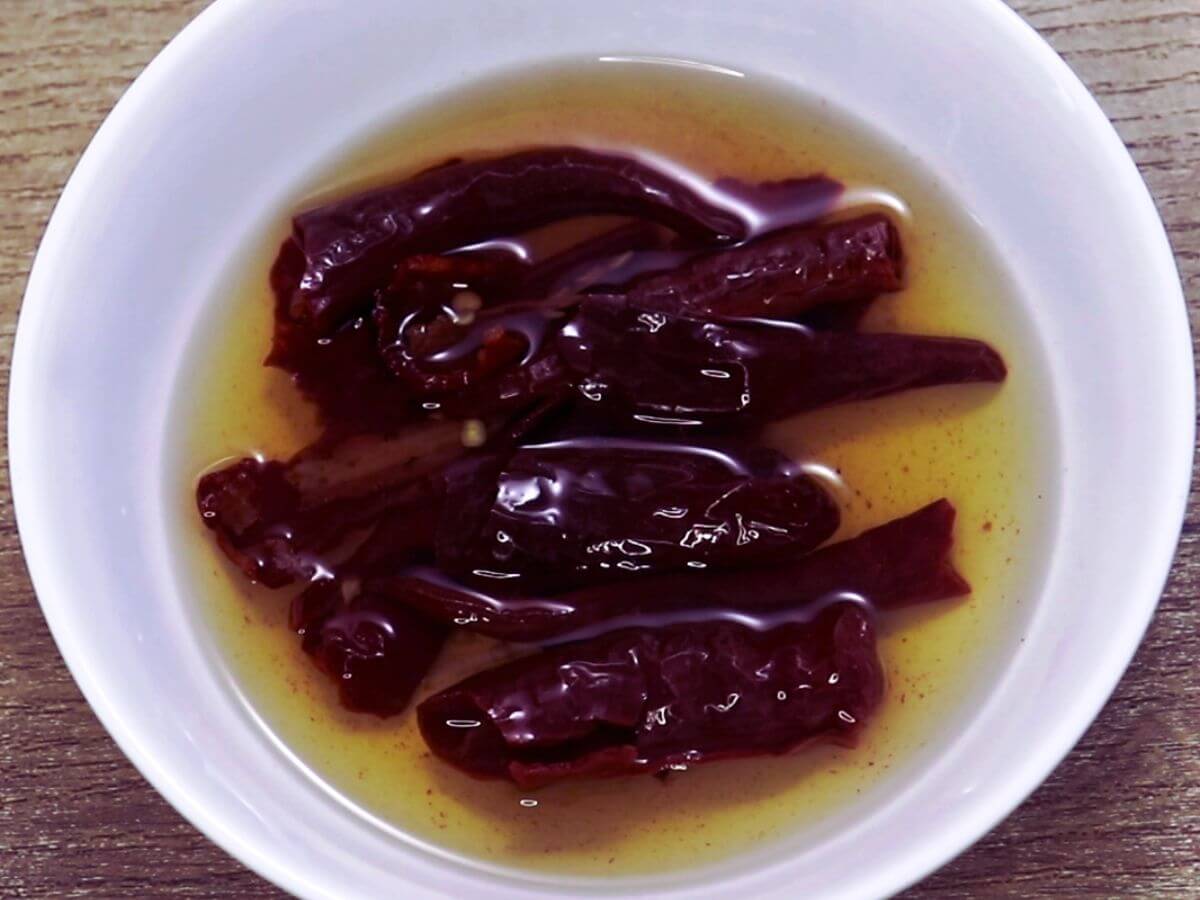 image showing soaking red chillies in ot water in a small bowl.