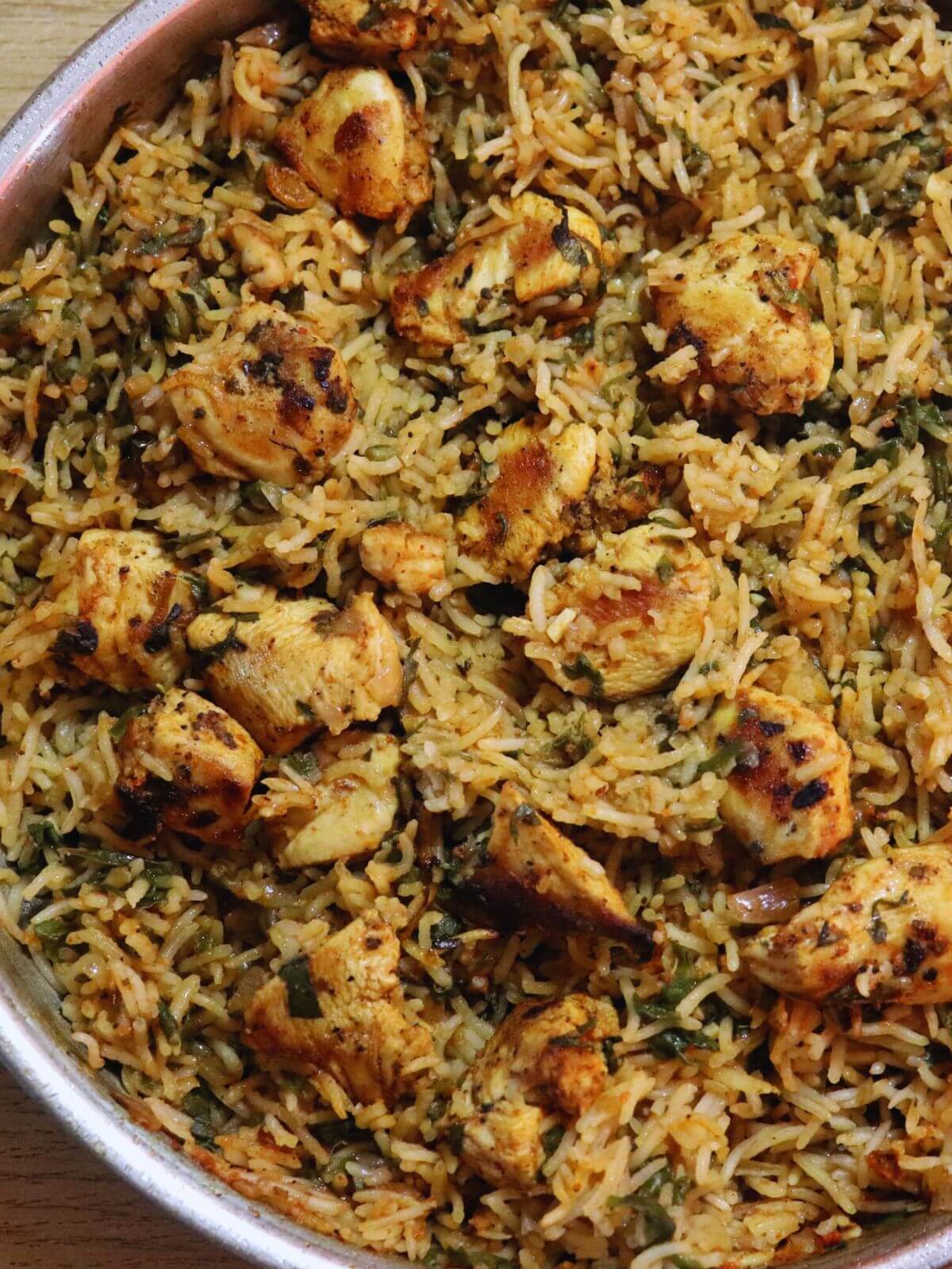 close-up of spinach chicken and rice in a skillet.