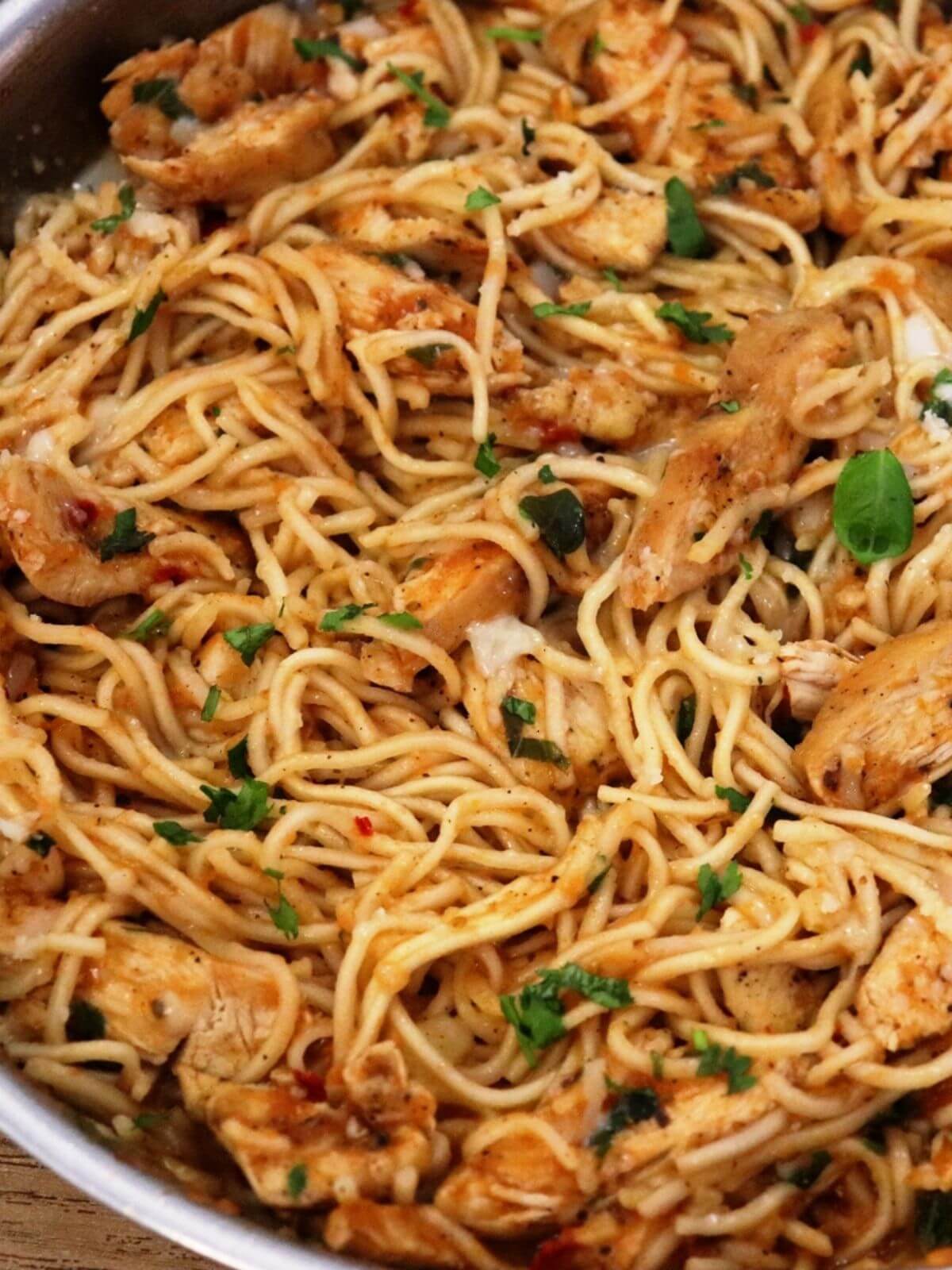 close-up of tomato basil chicken pasta in a skillet.