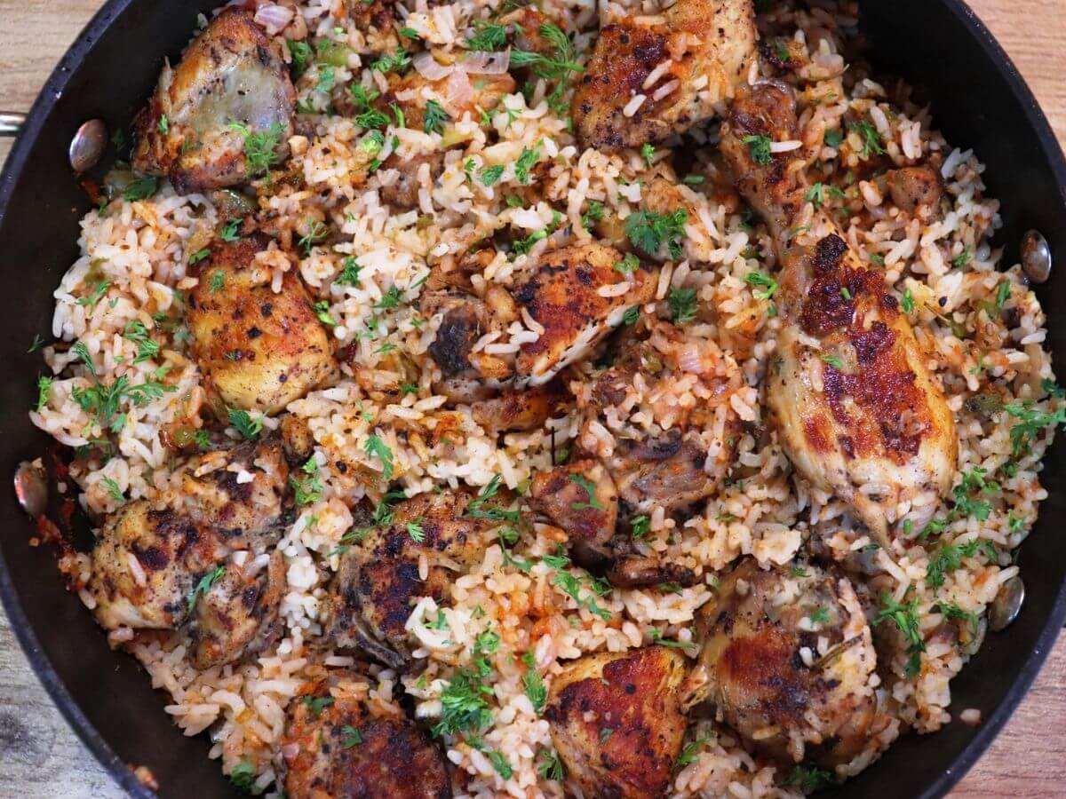 close-up of tomato chicken and rice in a pot.