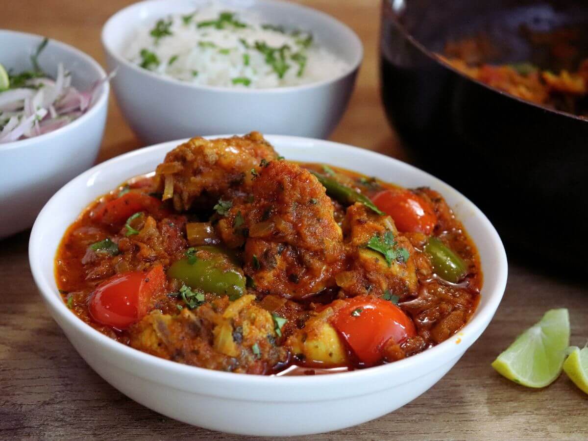 close-up of tomato chicken curry served in a bowl.
