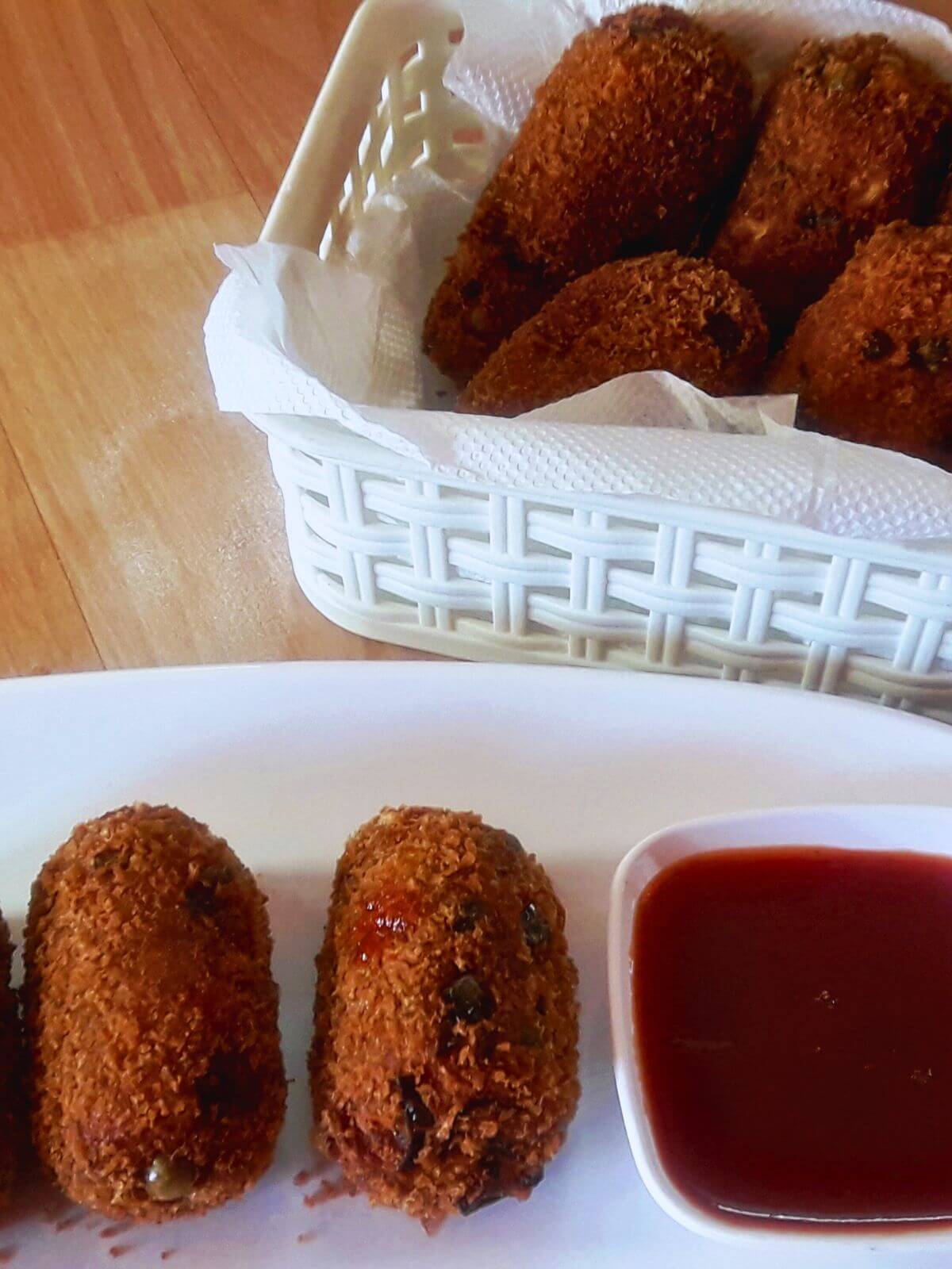 Vegetable nuggets are shown in a close-up, with tomato ketchup in a small bowl placed alongside.