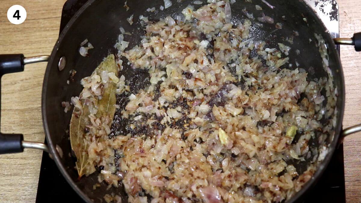Sauté sliced onions for chicken dopiaza in a pot.