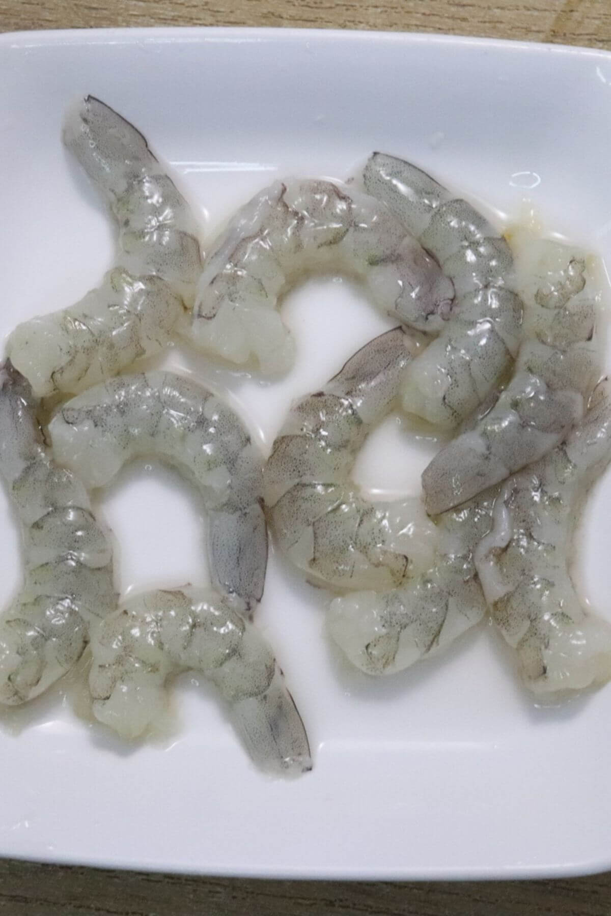 image of cleaned and deveined prawns placed on a white plate.