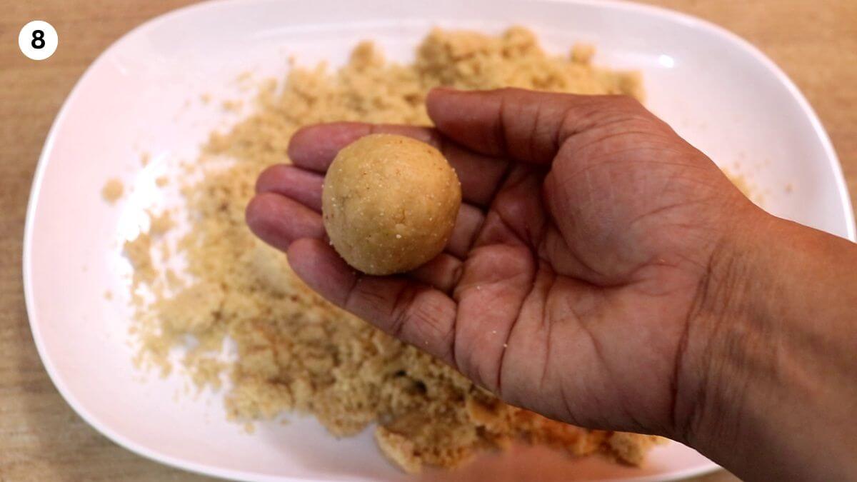peanut jaggery ladoo held in hands.
