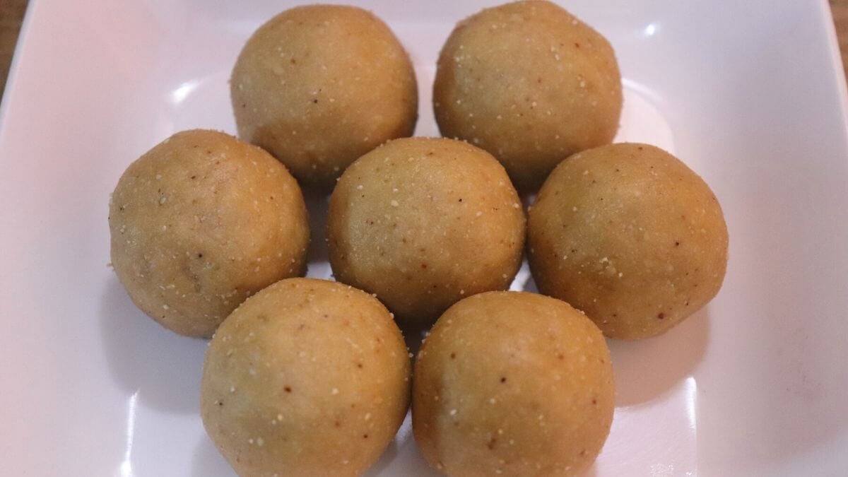 Peanut jaggery ladoos arranged on a white plate.
