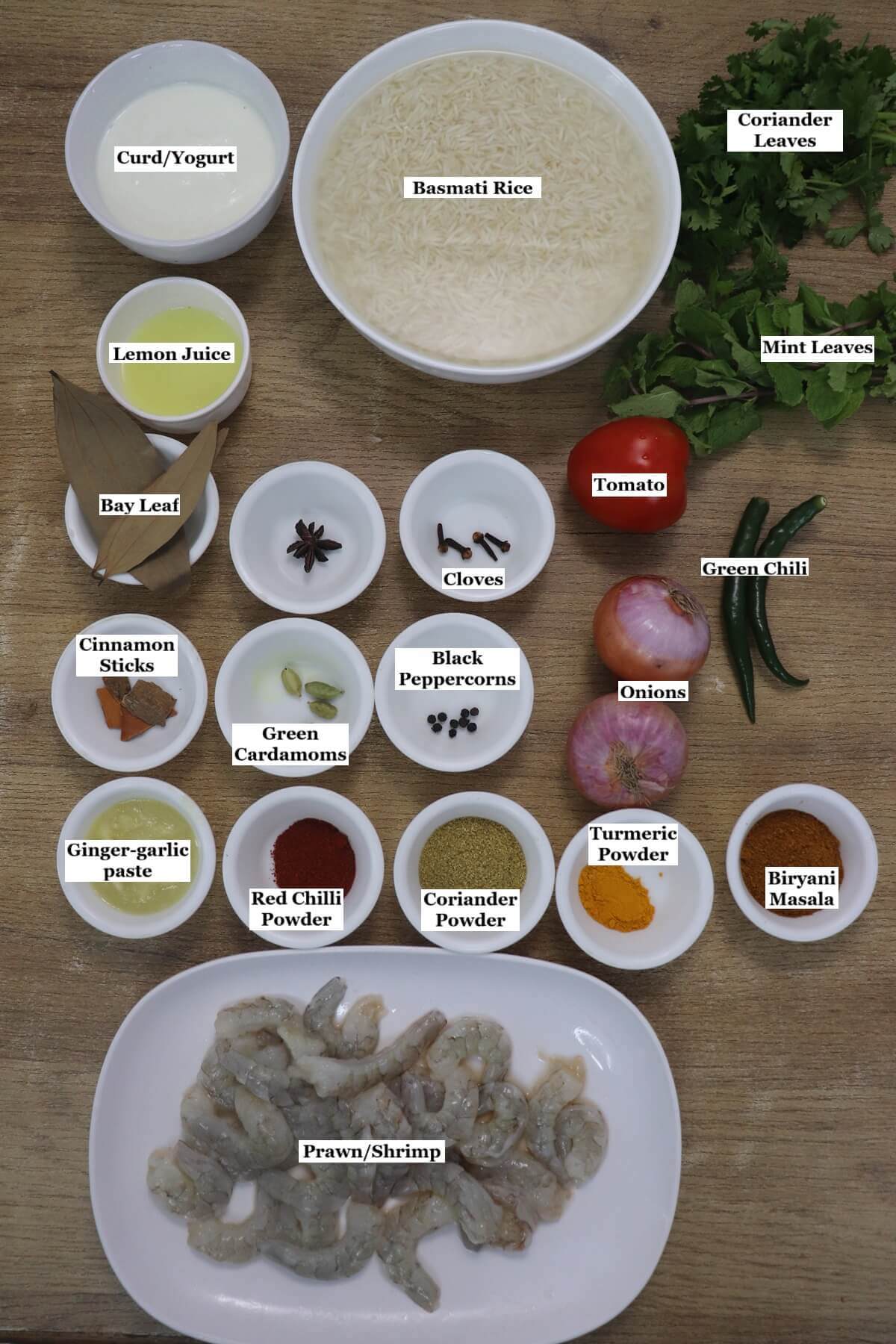individually labeled ingredients to make prawn biryani are laid out on a table.